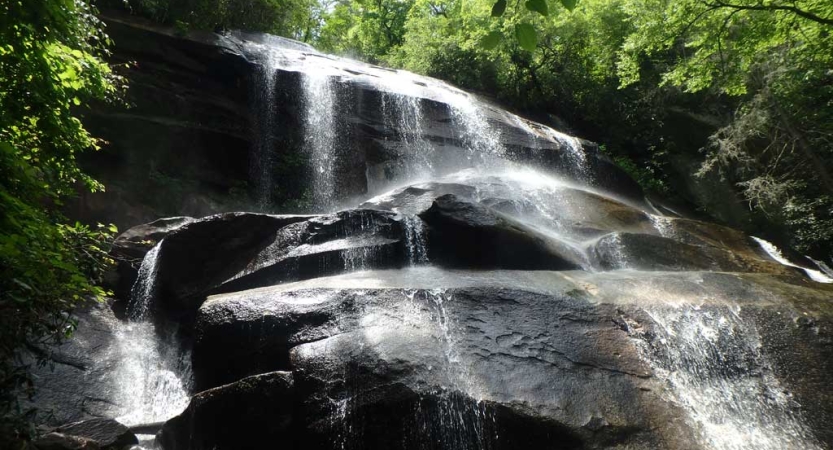 Water streams over a large rock formation